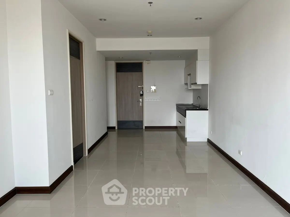 Spacious modern apartment interior with sleek kitchen and glossy tiled floors.