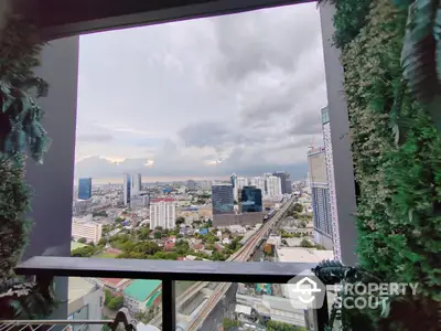 Stunning high-rise cityscape view from a modern balcony adorned with lush greenery, showcasing urban living at its finest with expansive skyline.