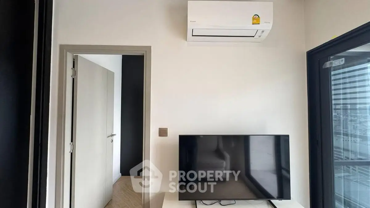 Modern living room with air conditioning and TV, featuring sleek design and natural light.