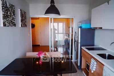Modern kitchen with sleek design, glass dining table, and contemporary appliances in a stylish apartment.