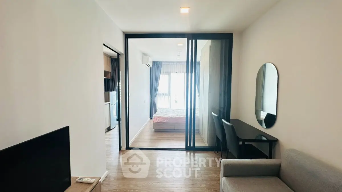Modern apartment interior with glass partition, cozy living area, and stylish bedroom.