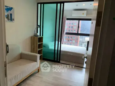 Modern apartment with cozy bedroom and sliding glass doors, city view.