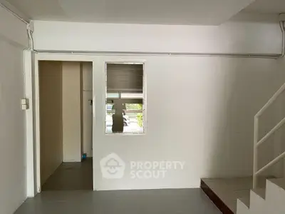 Minimalist interior space with white walls and staircase, ideal for creative renovation.