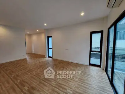 Spacious modern living room with wooden flooring and large windows