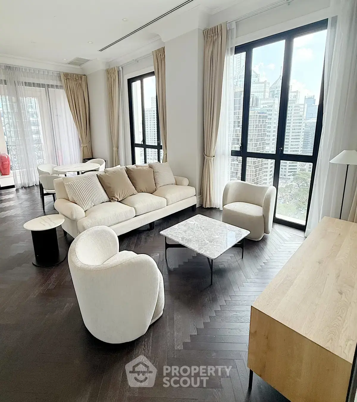 Luxurious living room with modern furniture and stunning city view through large windows.