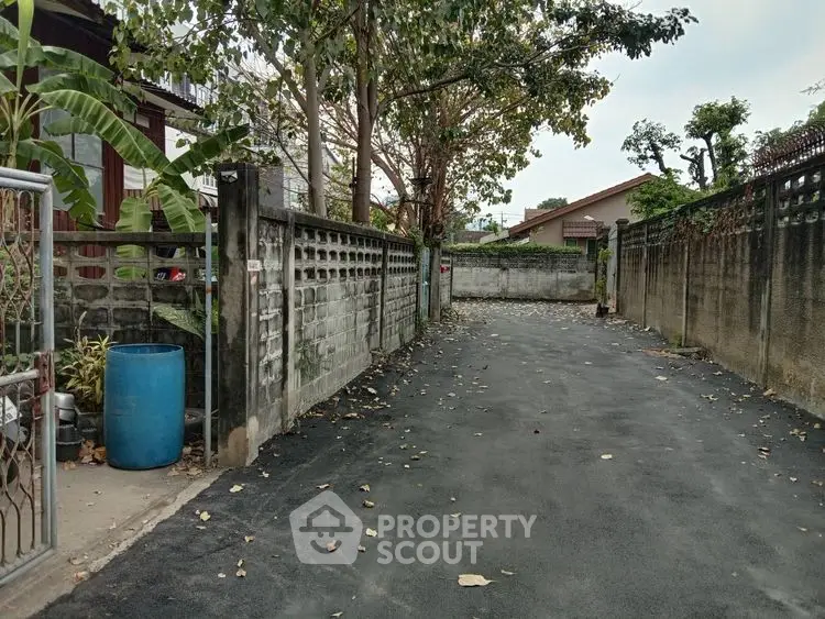 Quiet residential alley with paved path and surrounding walls
