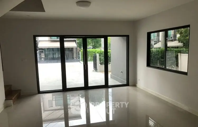 Spacious modern living room with large windows and glossy floor tiles