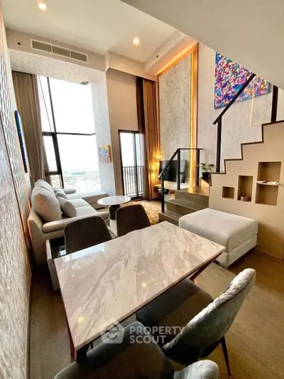 Luxurious modern living room with high ceilings, elegant staircase, and large windows offering stunning views.