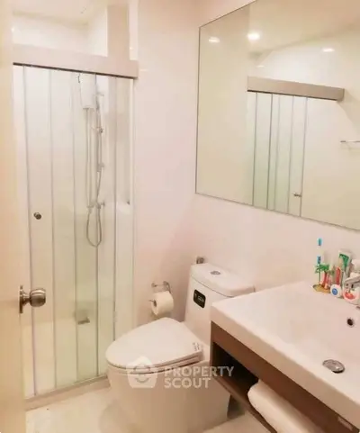 Modern bathroom with glass shower, sleek vanity, and contemporary fixtures.