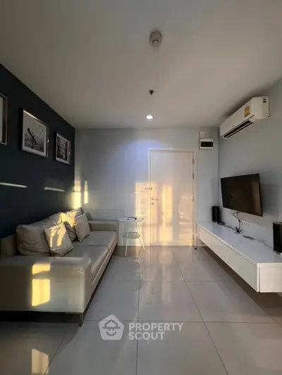 Modern living room with sleek design, wall-mounted TV, and stylish sofa in natural light.