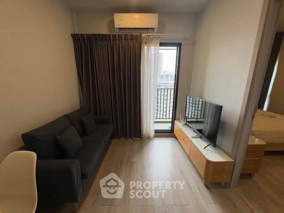 Modern living room with sleek furniture and balcony access in a stylish apartment.