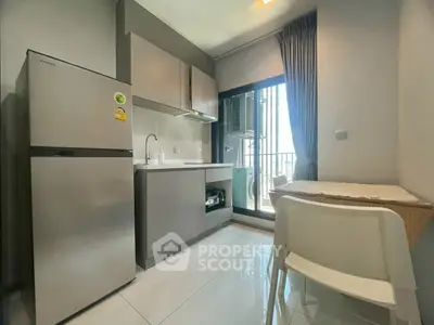 Modern kitchen with sleek appliances and balcony view in a stylish apartment.