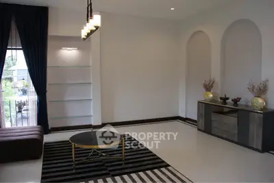 Elegant living room with modern decor, featuring a stylish coffee table, chic lighting, and a view of the balcony.
