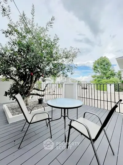 Charming outdoor balcony with modern seating and lush greenery, perfect for relaxation and enjoying the view.