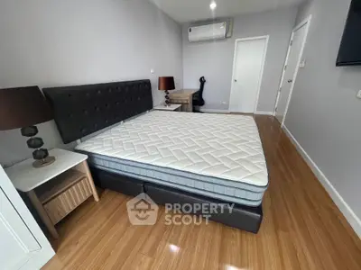 Spacious bedroom with modern decor and wooden flooring