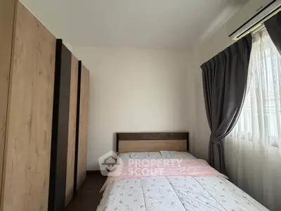 Cozy bedroom with modern wardrobe and large window with curtains, perfect for relaxation.