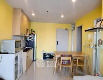 Charming kitchen with vibrant yellow walls, modern appliances, and cozy dining area.