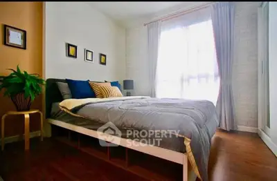 Cozy bedroom with modern decor and large window for natural light.