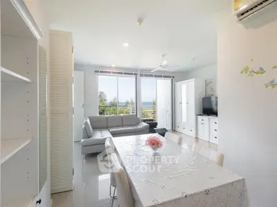 Bright and airy living room with modern furniture and stunning sea view from the balcony.