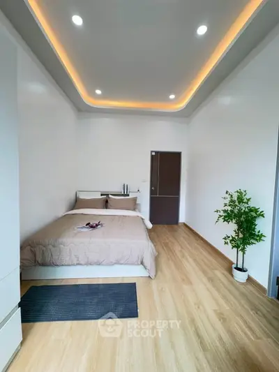 Spacious bedroom with modern lighting and wooden flooring