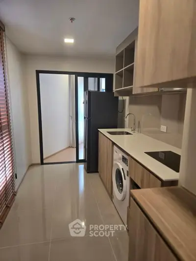 Modern kitchen with sleek appliances and washing machine in stylish apartment