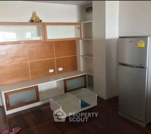 Modern living room with sleek storage and stainless steel fridge