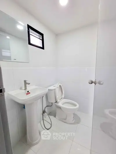 Modern white bathroom with sleek fixtures and natural light