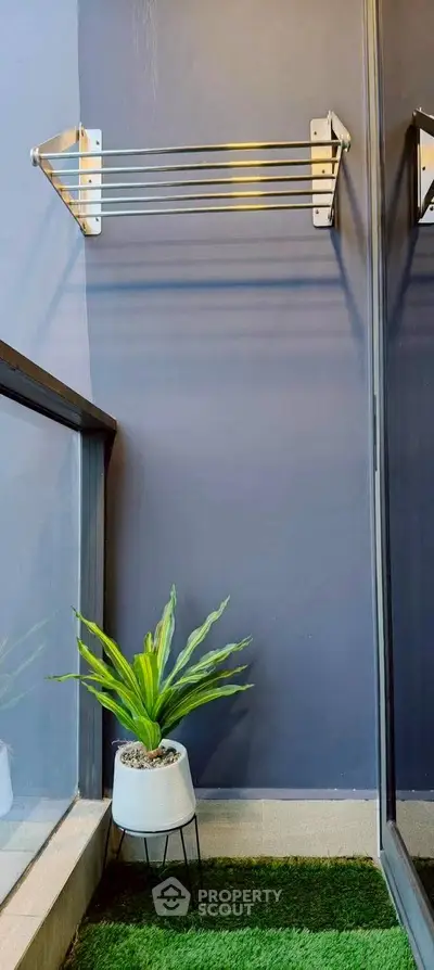 Charming small balcony with modern railing and potted plant, perfect for relaxation.
