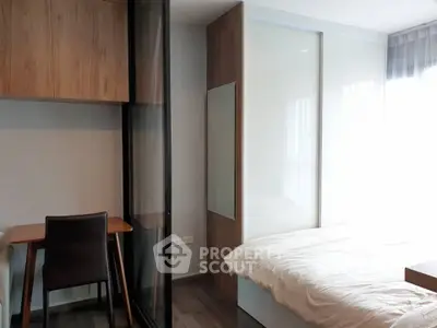 Modern bedroom with sleek design, featuring a cozy bed and stylish workspace.