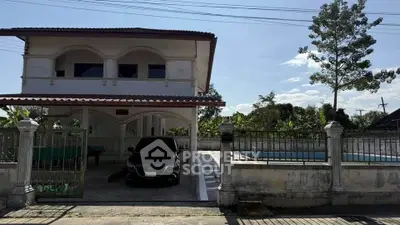 Charming two-story house with gated driveway and pool, perfect for family living.