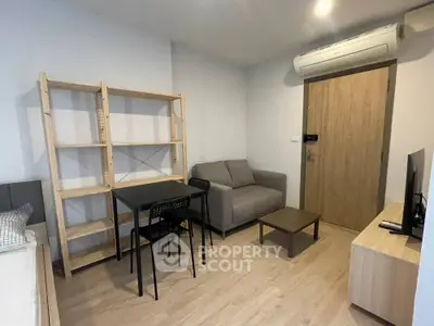 Modern living room with cozy sofa, dining table, and wooden shelving unit.