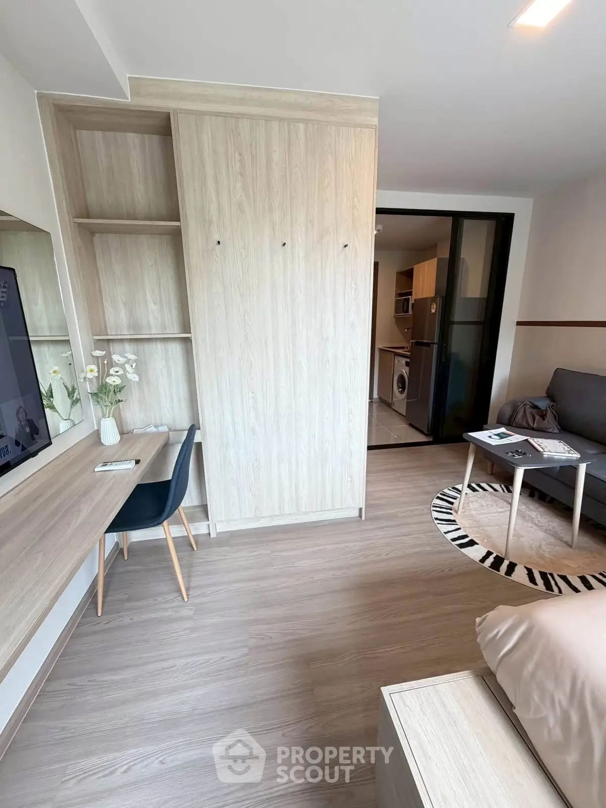 Modern studio apartment with stylish wooden furniture and cozy workspace