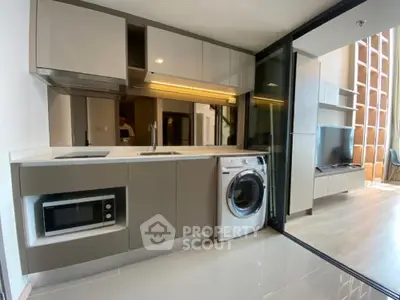 Modern kitchen with sleek cabinetry, built-in appliances, and open layout to living area.