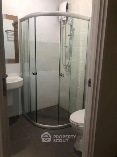 Compact bathroom with modern shower enclosure and sleek fixtures.