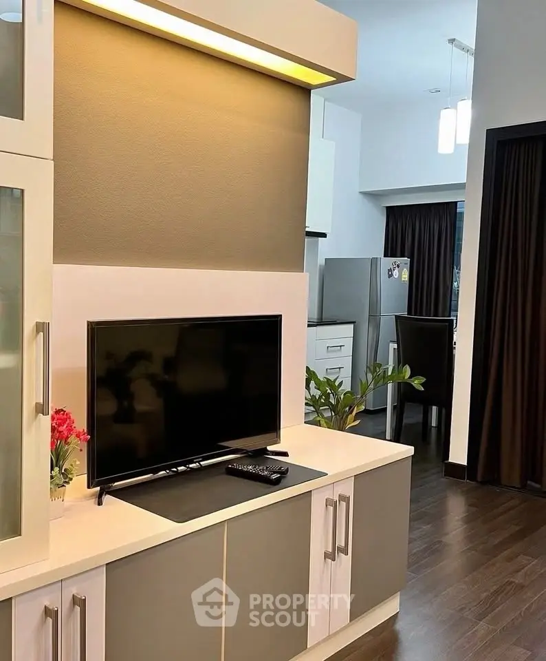 Modern living room with sleek TV unit and open kitchen view