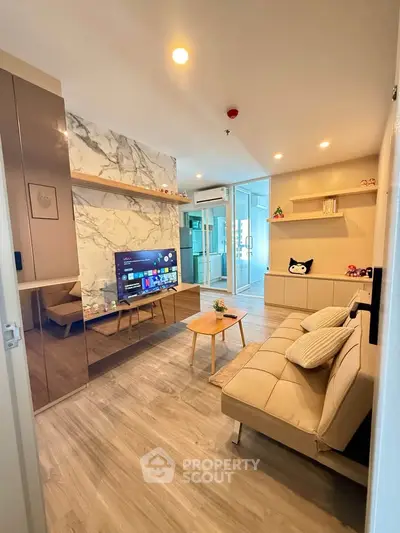 Modern living room with stylish decor and open layout, featuring a cozy sofa and wall-mounted TV.