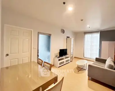 Modern living room with cozy sofa and TV unit, bright natural light, and stylish decor.