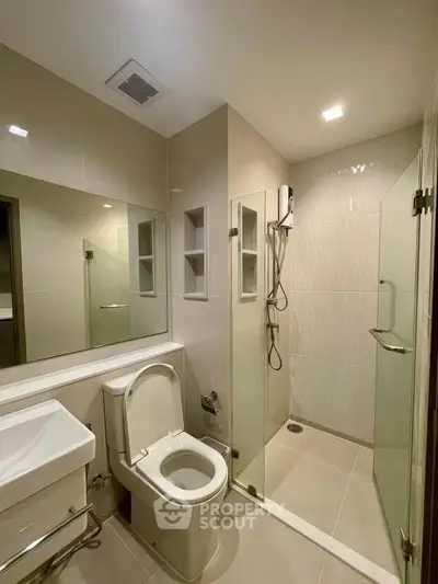 Modern bathroom with glass shower enclosure and sleek fixtures