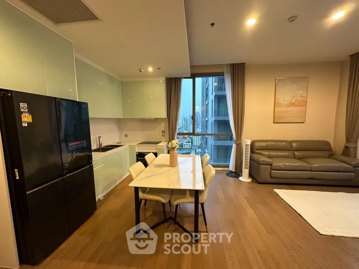 Modern open-layout kitchen and living room with city view and sleek furnishings.