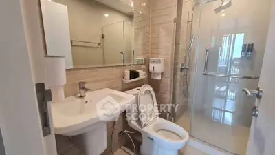 Modern bathroom with glass shower and sleek fixtures in a contemporary apartment.