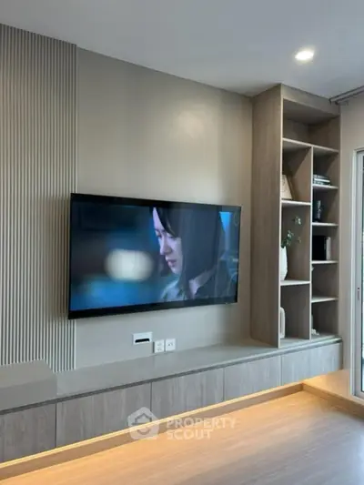 Modern living room with built-in TV unit and shelving, sleek design