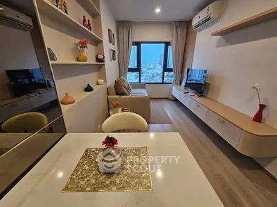 Modern living room with city view, stylish decor, and sleek furniture in a high-rise apartment.