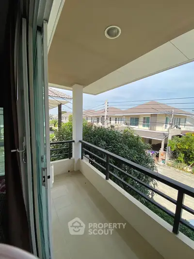 Charming balcony view in a suburban neighborhood with lush greenery and modern homes.