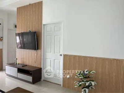 Modern living room with wall-mounted TV and stylish wood paneling