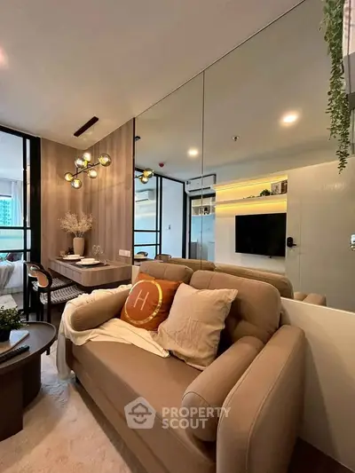 Modern living room with stylish decor and open layout, featuring a cozy sofa and elegant lighting.