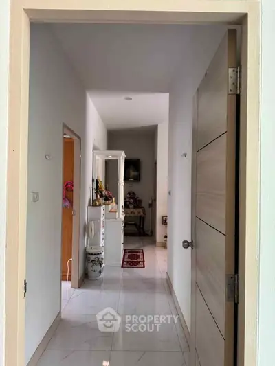 Bright hallway with modern decor and white tiled flooring in a contemporary home.