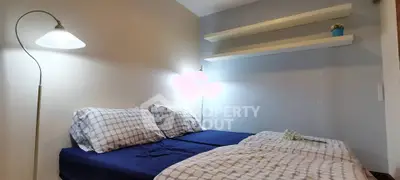 Cozy bedroom with modern lighting and stylish shelving, perfect for relaxation.