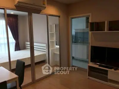 Modern apartment interior with bedroom and living area, featuring sleek furniture and ample natural light.