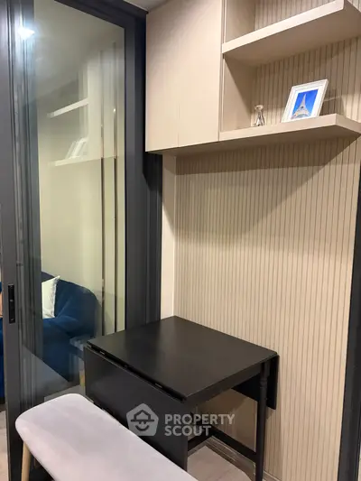 Modern study nook with sleek black desk and shelving in stylish apartment