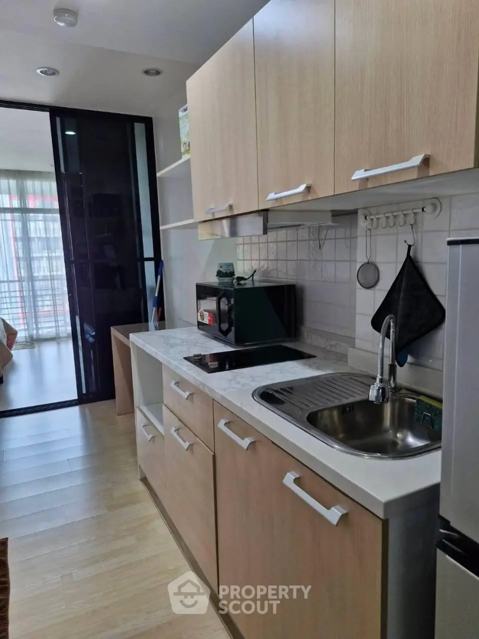 Modern kitchen with sleek cabinetry and stainless steel sink in a stylish apartment.